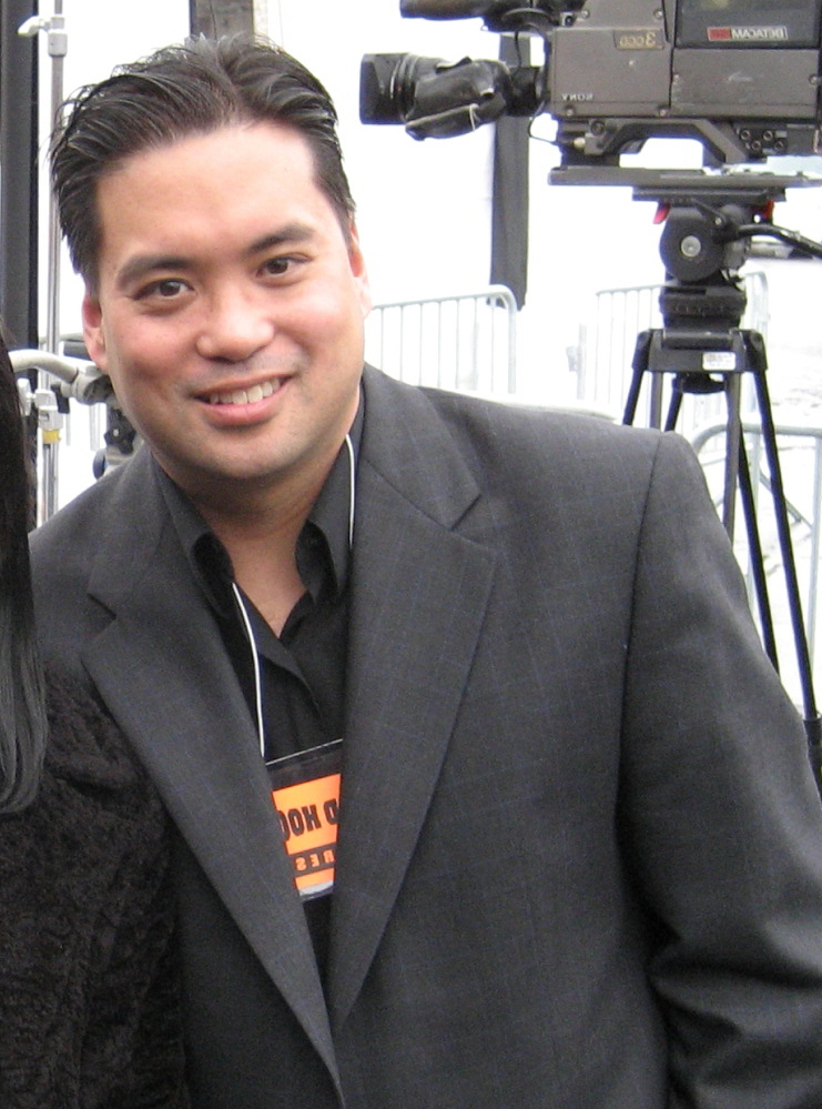 Richard R. Lee, television producer, leaning against a wall