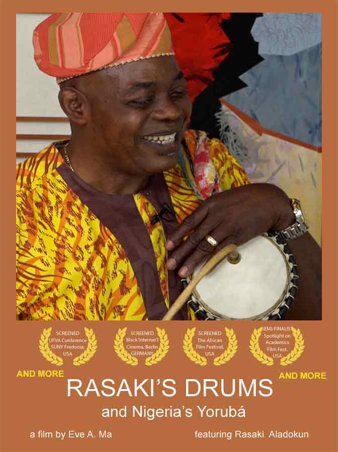head of smiling man wearing bright clothes and a red cap, holding a drum